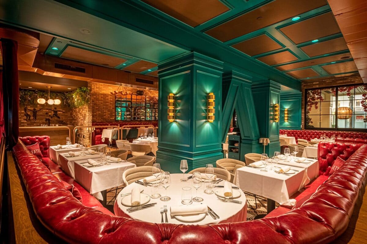 Sala del restaurante Tatel Beverly Hills destaca el imponente sofá de cuero rojo acolchado y el color turquesa de las columnas.